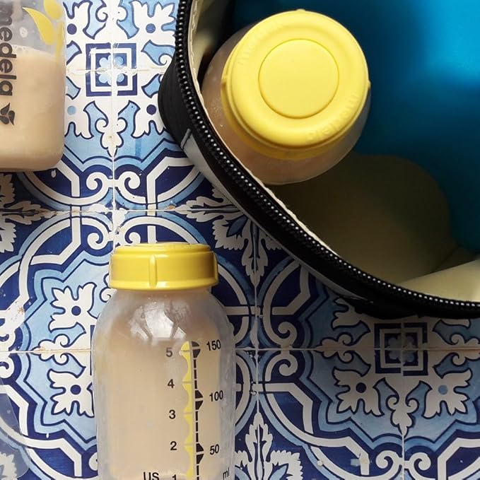 Medela breast milk bottles displayed, with one bottle placed inside the cooler bag for storage.