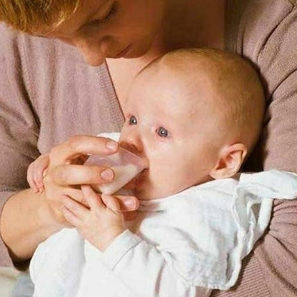 Mom feeding baby using Medela disposable feeding cup for precise milk measurement and safe feeding.