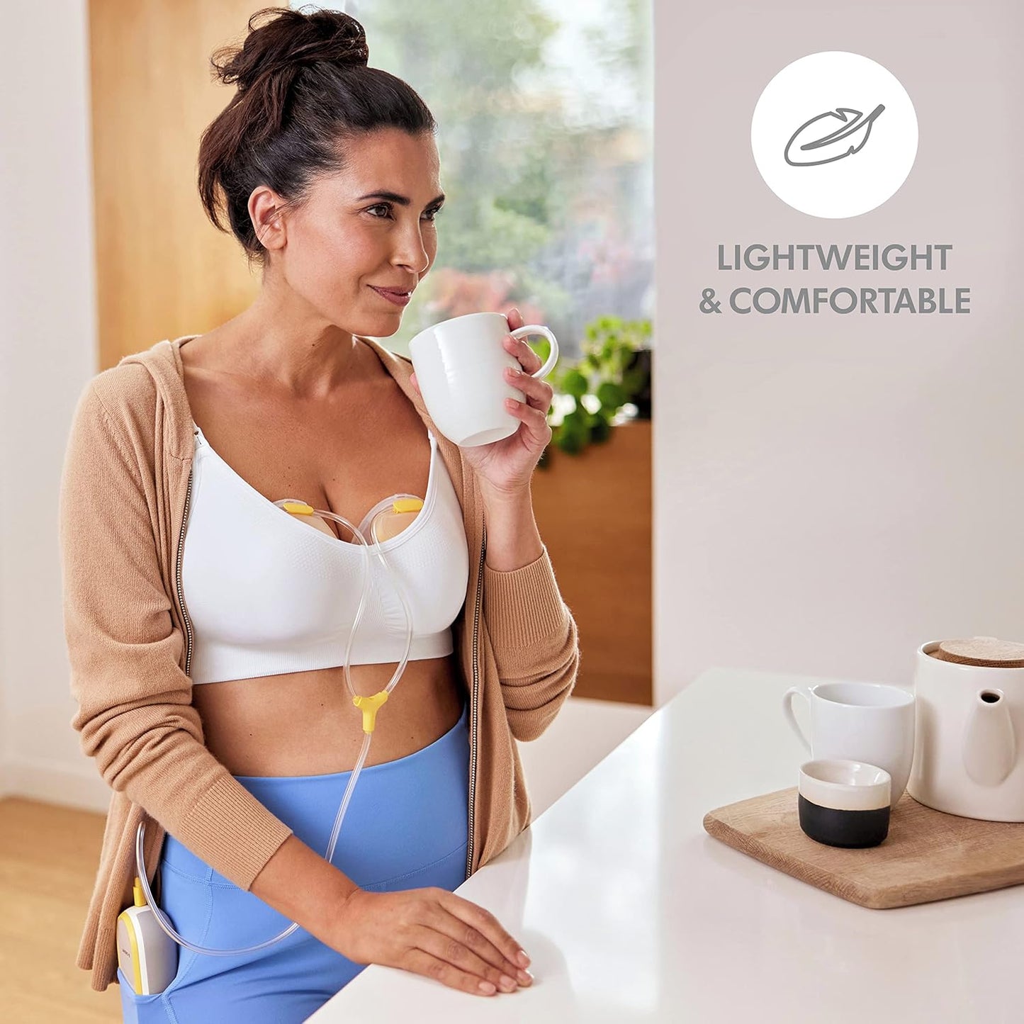 Mom using Medela Duo Electric Breast Pump while having coffee; text with icon highlighting lightweight and comfortable design.