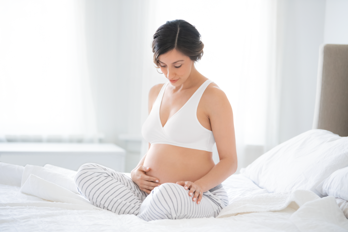 Mom wearing Medela white sleep bra, looking comfortable and relaxed