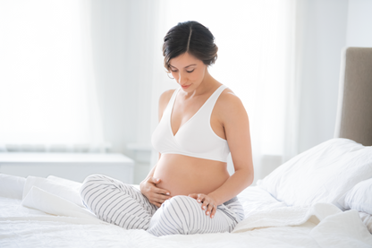 Mom wearing Medela white sleep bra, looking comfortable and relaxed
